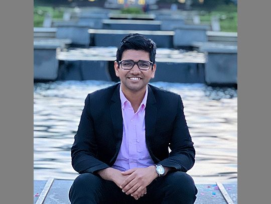 Nakul Garg sitting at the foot of the UMD Mall fountain