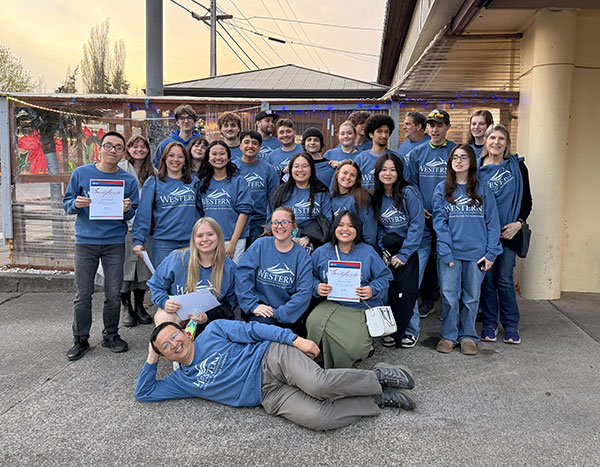The VITA volunteer team pose for a photo wearing matching blue WWU sweatshirts