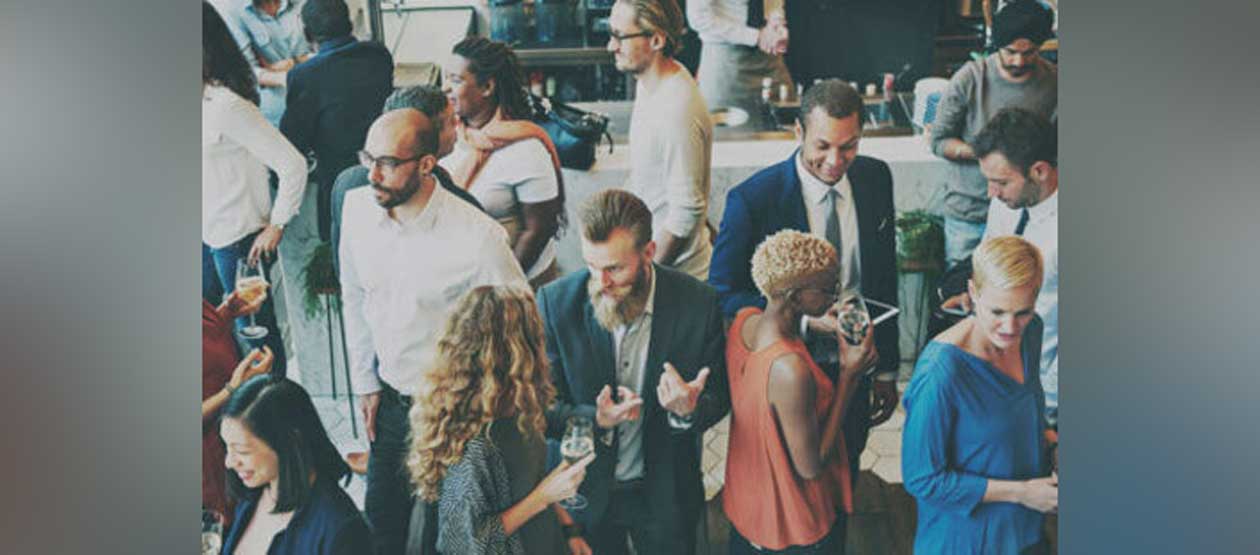 a crowd of people dressed in business casual mixing and mingling