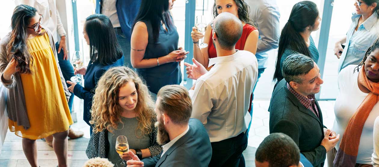 people dressed in business casual mix and mingle in a social setting