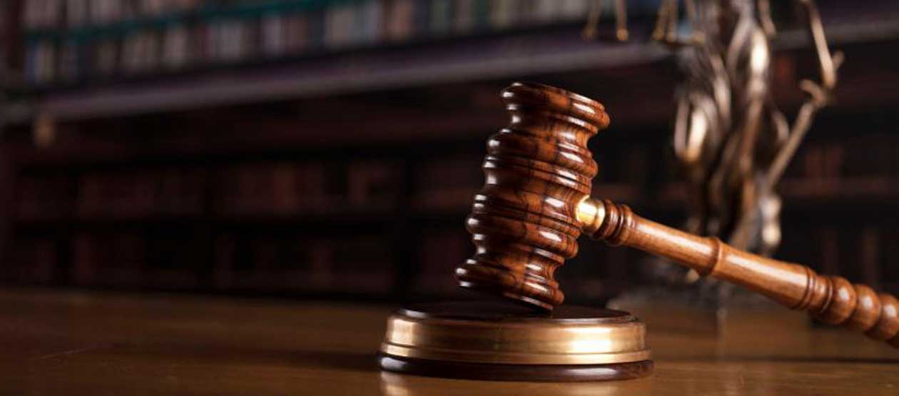 a gavel rests on a round, wooden block atop a wooden table