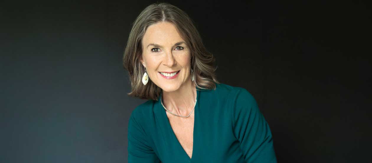 Cheri Torres poses in front of a dark backdrop
