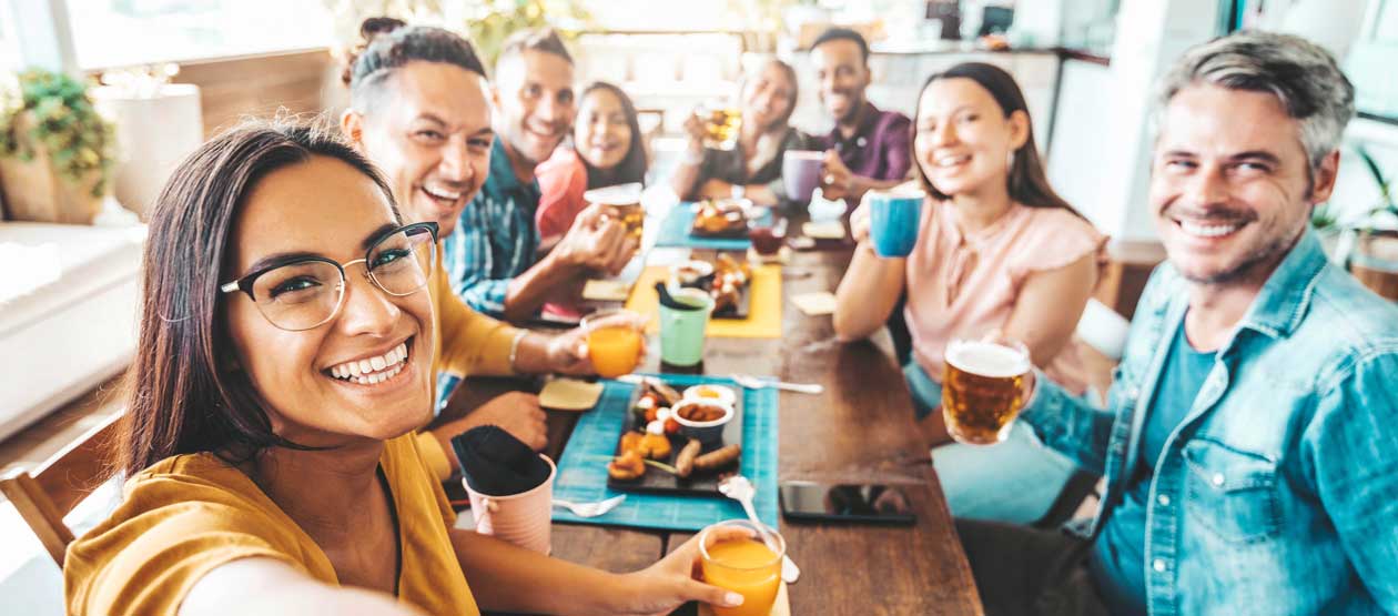a group of people gather around a table for a happy hour