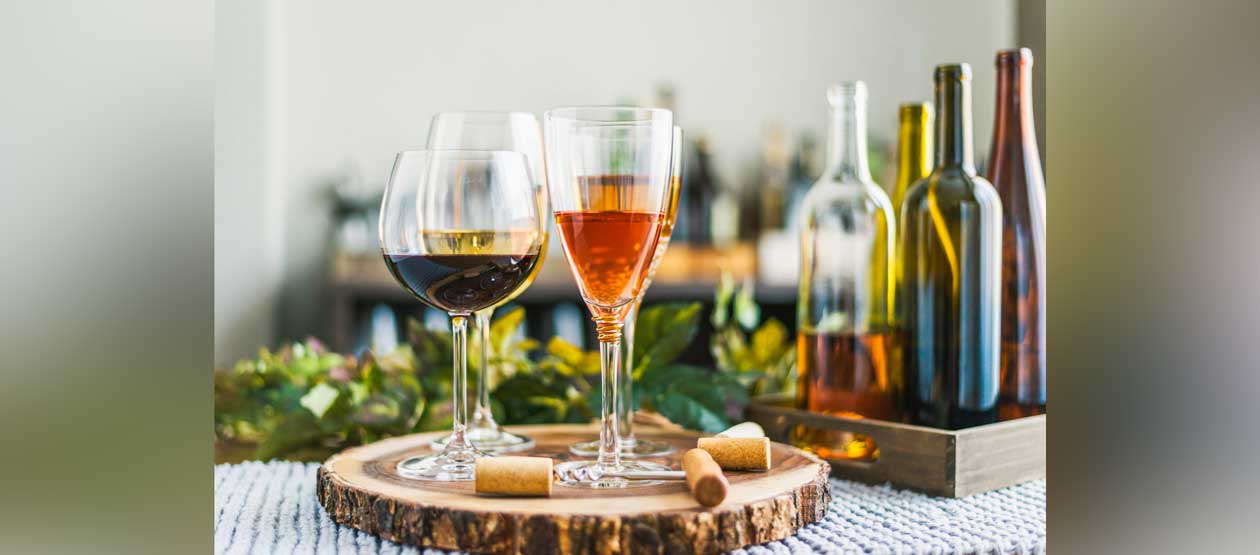 a collection of wine glasses and bottles are displayed on a clothed table a collection of wine glasses and bottles are displayed on a clothed table