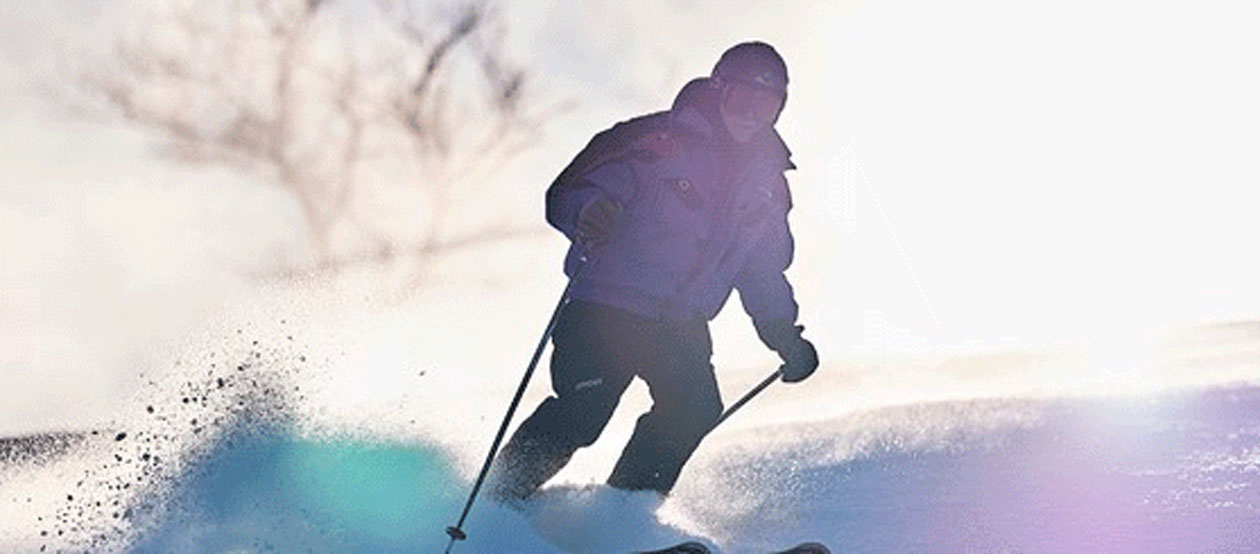 a person skiing on snow, which poles and snow flying