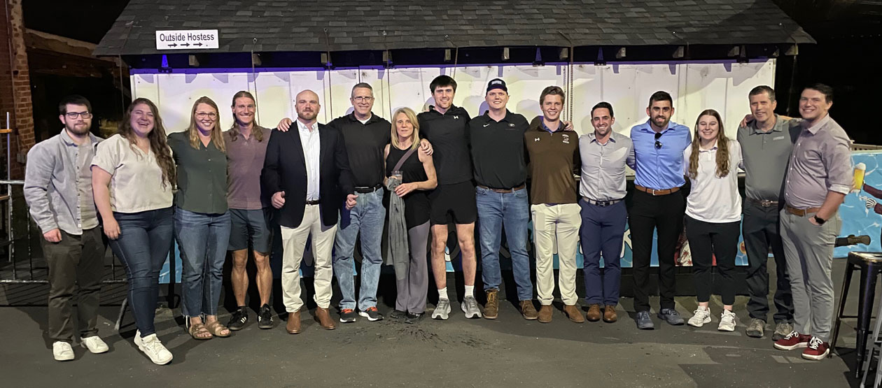 group of 15 people stand together for a group photo 