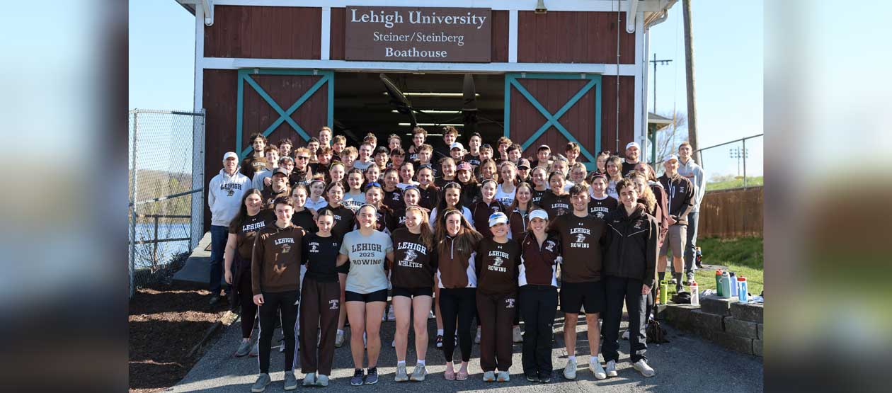 Lehigh Mountain Hawks Men's Soccer team from 2000 gathered in a group photo around their championship trophy